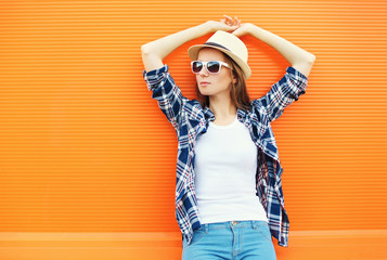 Fashion pretty woman wearing a straw hat and sunglasses over ora