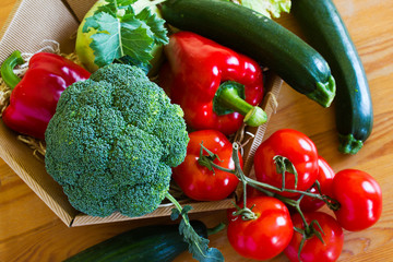 Basket with fresh vegetables on a wooden table