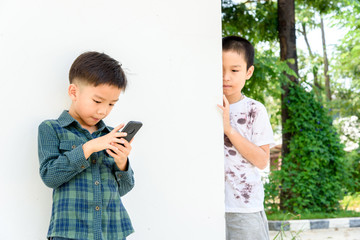 Young boy play smartphone compare with poor boy