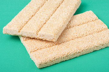 Honey bars with sesame seeds on green background