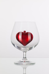 Red heart inside a glass of cognac