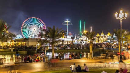 Main square and lake in Global Village with crowd and attractions timelapse in Dubai, UAE
