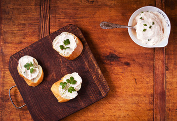 Snack time with tasty baguette and savory cream on a wooden table