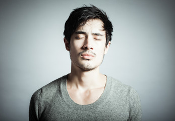 Thoughts and feelings concept. Portrait of young man in studio thinking. 