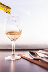 Wine poring into a glass in a restaurant setting. 