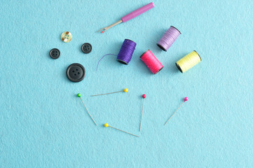 Fototapeta na wymiar A variety of needlework accessories displayed against a blue background