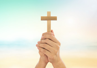 Human hands holding a cross