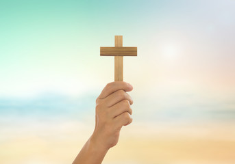 Human hands holding a cross