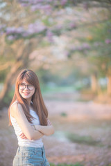 Asian woman  ware glasses with long hair stand in front of  tree  in sunset time