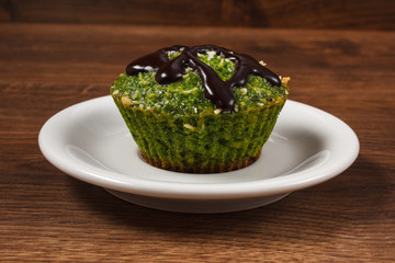 Fresh muffin with spinach, desiccated coconut and chocolate glaze, delicious healthy dessert