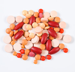 Colorful medical tablets and capsules on white background, health care concept
