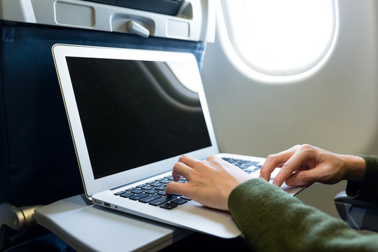 Woman use of laptop computer at airplane