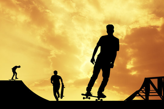 boys with skateboarders at sunset