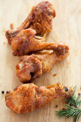 fried chicken with rosemary and pepper on chopping block