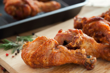 fried chicken with rosemary and pepper on chopping block