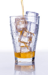 Pooring soft drink in a glass with ice