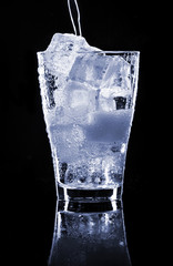 Pooring soft drink in a glass with ice