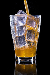 Pooring soft drink in a glass with ice