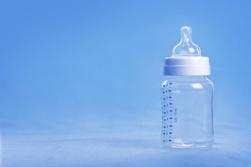 Baby milk bottle on a blue sheet