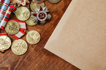 Medals of the USSR and the merits of different years and paper on a table.