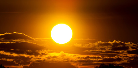 Amazing view on the orange sky, sunset sun and clouds