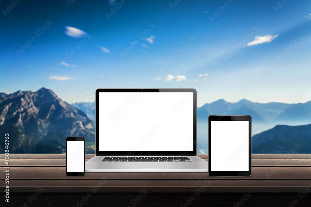 Poster Laptop, tablet and smart phone responsive display devices on table. Isolated white screen for mockup presentation. Mountain nature landscape in background
