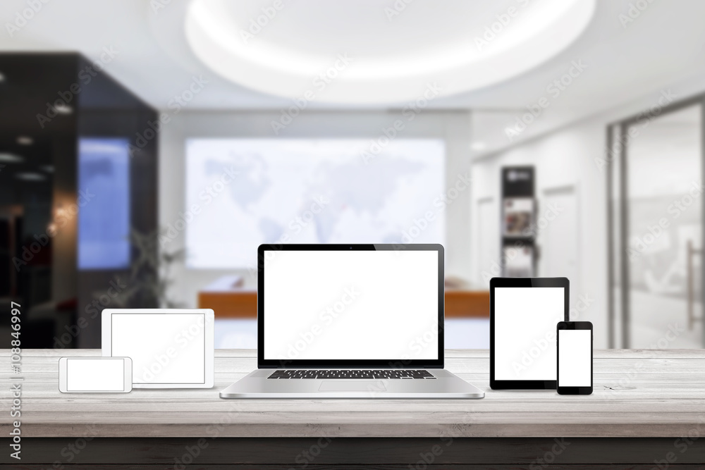 Poster Laptop, tablet and smart phone responsive display devices on table. Isolated white screen for mockup presentation. Office interior in background