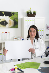 Ärztin bzw. Arzthelferin hält weißes Schild mit Copyspace hoch - obrazy, fototapety, plakaty