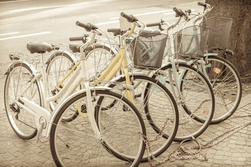 Naklejka na ściany i meble Bikes parked on the pavement. Vintage effect.