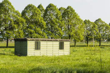 A metal hut in a green and sunny field
