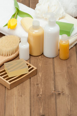 Fototapeta na wymiar Spa Kit. Shampoo, Soap Bar And Liquid. Shower Gel. Towels. Woode