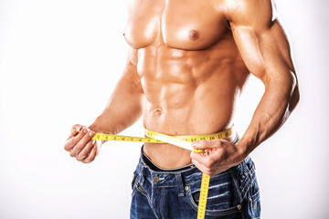 Strong Athletic Man showing muscular body and sixpack abs over white background.Muscular man on...
