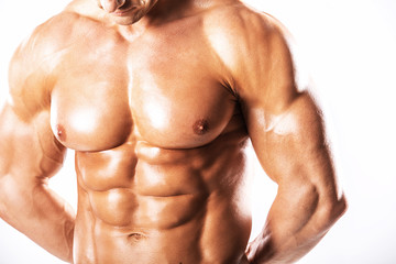 Fototapeta premium Strong Athletic Man showing muscular body and sixpack abs over white background.Muscular bodybuilder guy doing exercises with dumbbells over white background.Muscular man on white background