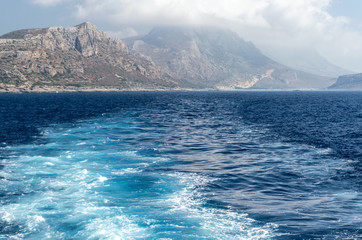 Fototapeta na wymiar The rocky coast of the Mediterranean sea against the blue sky and clouds.
