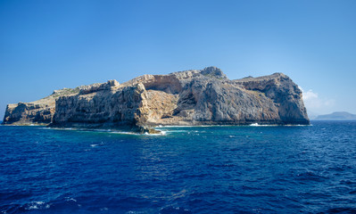 Fototapeta na wymiar The rocky coast of the Mediterranean sea against the blue sky on a clear summer day 