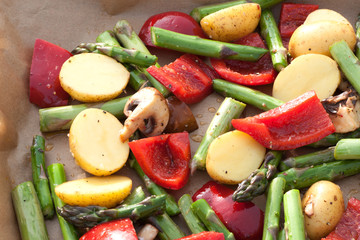 Mediterranean vegetables with asparagus, peppers, potatoes and mushrooms on a baking tray