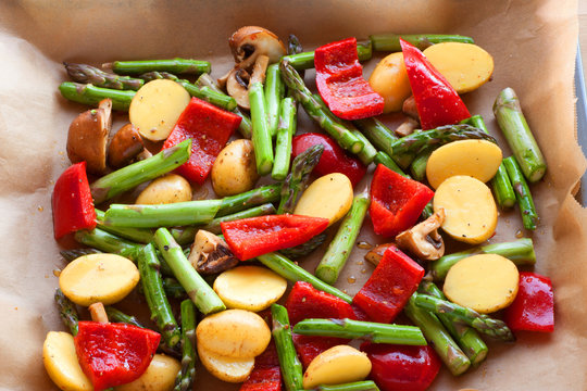 Mediterranean vegetables with asparagus, peppers, potatoes and mushrooms on a baking tray