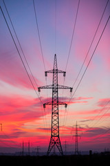 High voltage electricity pylon system on sunrise background