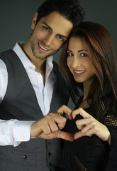 Smiling couple forming hearts shape