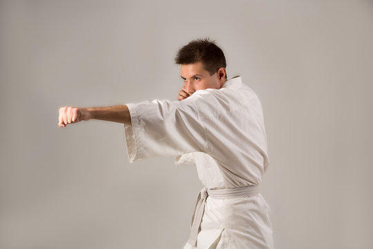 Young man in white kimono training martial art 