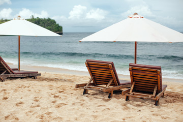  chairs and white umbrella on the beach. Banner