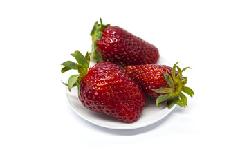 Fresh strawberries on a plate on white background