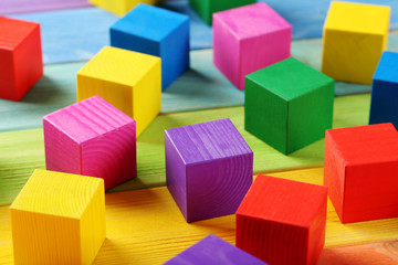 Fototapeta premium Colorful wooden toy cubes on a colorful wooden background