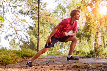 Young man stretching before jogging, cross country runner