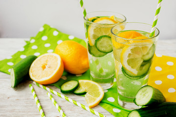 
detox , healthy and refreshing drink ,Nutritious cold sparkling water with fresh green cucumber and yellow lemon on a wooden background