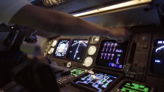 Detail of 747 pilot's hand adjusting instruments in the cockpit of a jumbo jet.  Originally recorded in 4K.