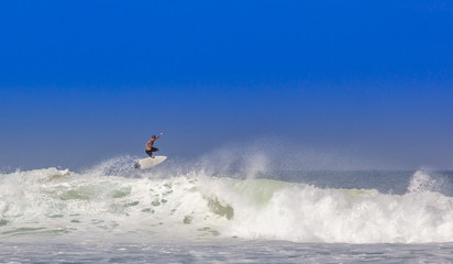 Surfista voando sobre a onda.