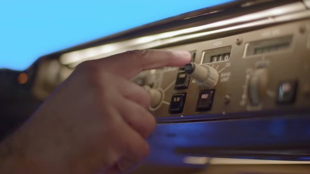 Detail of 747 pilot's hand setting controls on auto-pilot navigation panel.  Originally recorded in 4K.