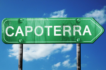 Capoterra road sign, vintage green with clouds background