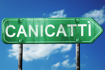 Canicatti road sign, vintage green with clouds background